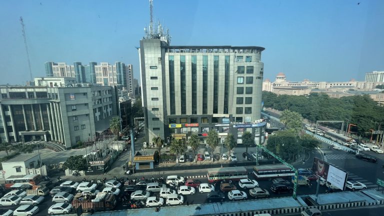 Traffic surrounds a highrise in India