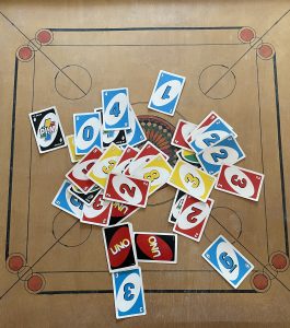 Uno card placed on a carrom board.

