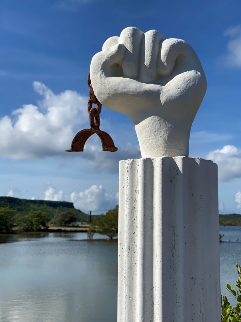 Cura?ao’s statue which consists of a raised fist holding a broken chain, which commemorates the Slave Revolt of 1795.