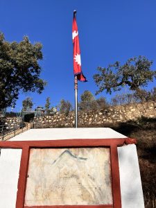 A flag standing proudly atop a stone. 