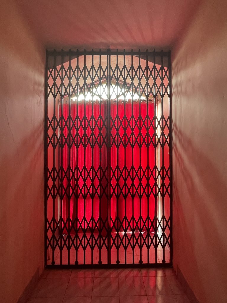 Sunlight passing through a small window in a locked balcony hallway