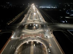 An aerial view of a express highway at night with streetlights and car headlights