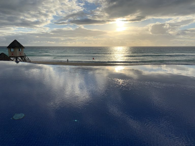 View from an infinity pool overlooking a lifeguard hut and the Caribbean Sea (JW Marriott Cancun Resort & Spa, Cancún, Quintana Roo, Mexico).