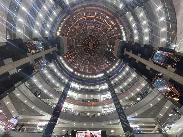 Looking up toward the ceiling of a shopping mall that has several levels