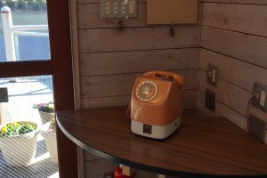 An orange and white telephone is situated on the table.