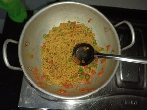 View larger photo: Instant noodles in an aluminium pan with a steel ladle.