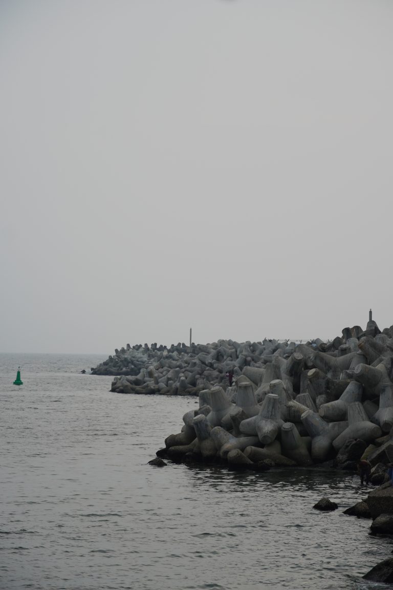 Scenic historic beachside view with waves gently caressing the shore protected by sea wall, capturing the serenity of a bygone era.