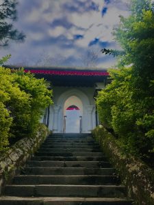 stairway to a white gate, with green trees