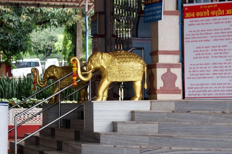 Golden sacred elephant sculpturess at the entrance of a temple.