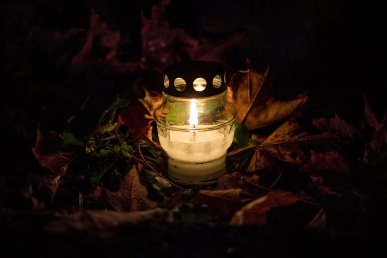 A candle on orange leaves.