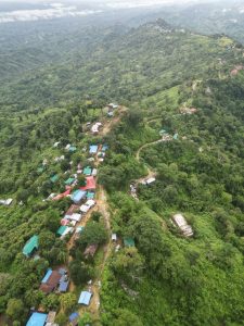 Drone view of a village on the mountain range and muddy roads along the peak. A perfect destination for a vacation into the mountains.