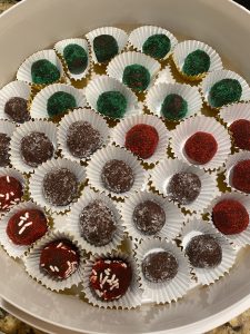a tray of rolled chocolate sprinked candies in paper cups
