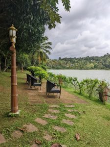 View of the river from riverbank with chairs. Rainy clouds in the background

