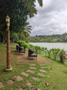 View of the river from riverbank with chairs. Rainy clouds in the background