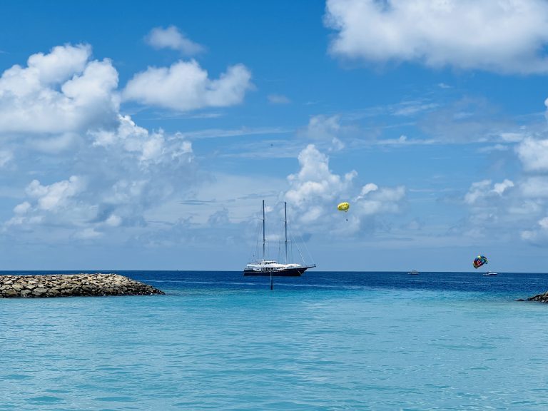 Parasailing on a blue sea with a yacht in the background