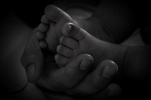 Tiny baby feet cradled delicately in the warmth of a mother's hands.