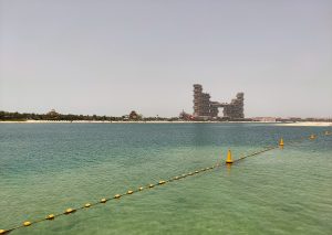 A picturesque view of Atlantis, The Royal in Dubai, captured from the opposite side of the beach, showcasing its grandeur against the serene backdrop of the coastline.