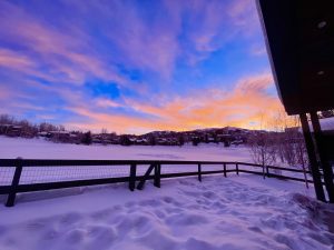 Early morning sunrise beginning over Steamboat Ski Resort in the background with snow covered Rollingstone Ranch Golf Course in the midground (Steamboat Springs, Colorado)