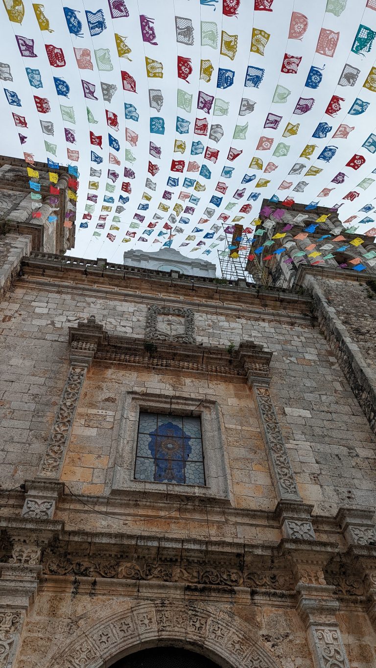 Colourful banners flying high above a church in Cancun, Mexico.