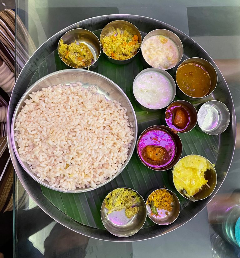 Kerala thali meals, with rice in a big bowl and different curries in small bowls.