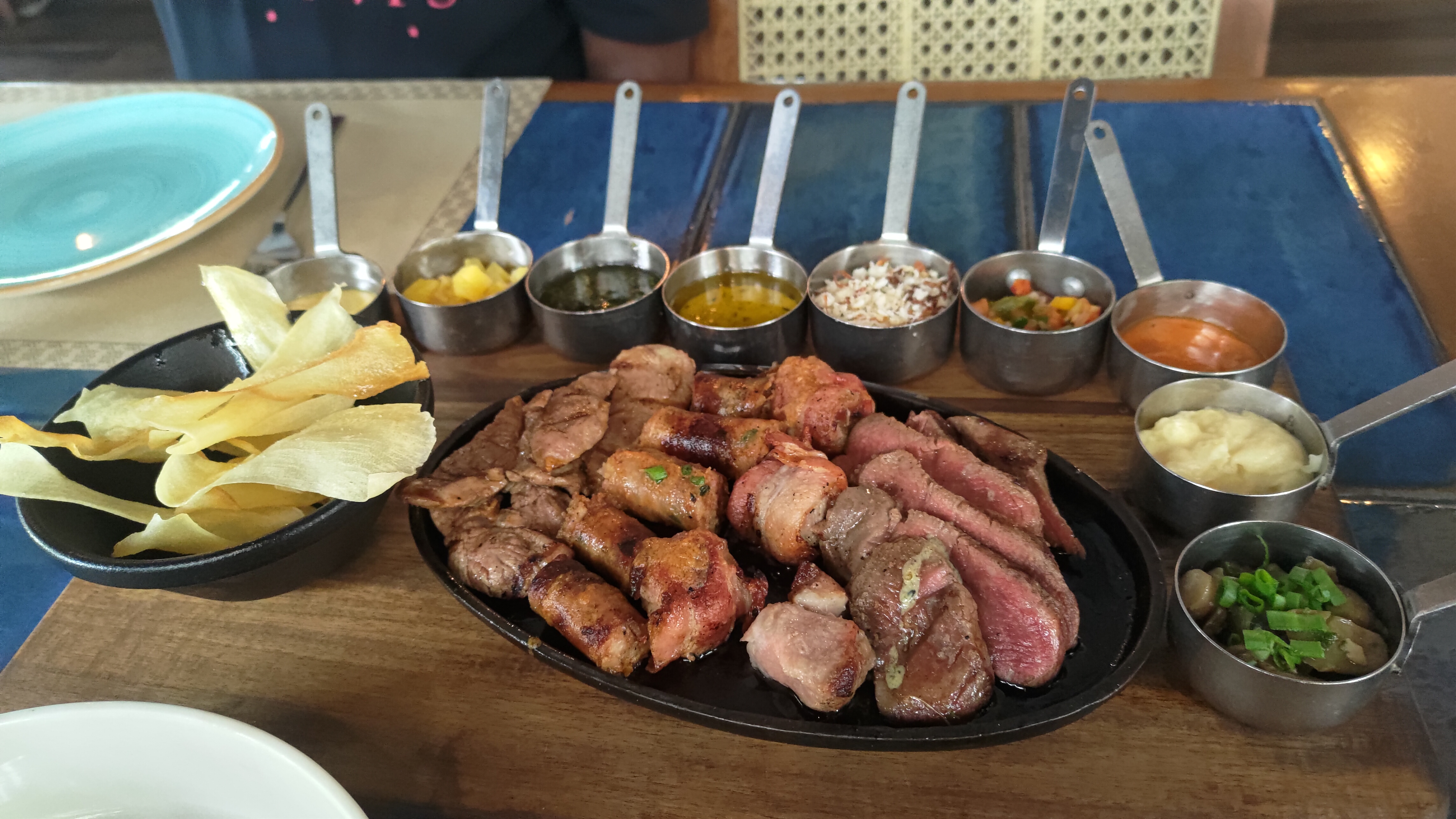 Meat platter accompanied by mashed tapioca, tapioca fry, grilled pineapple and sauces.