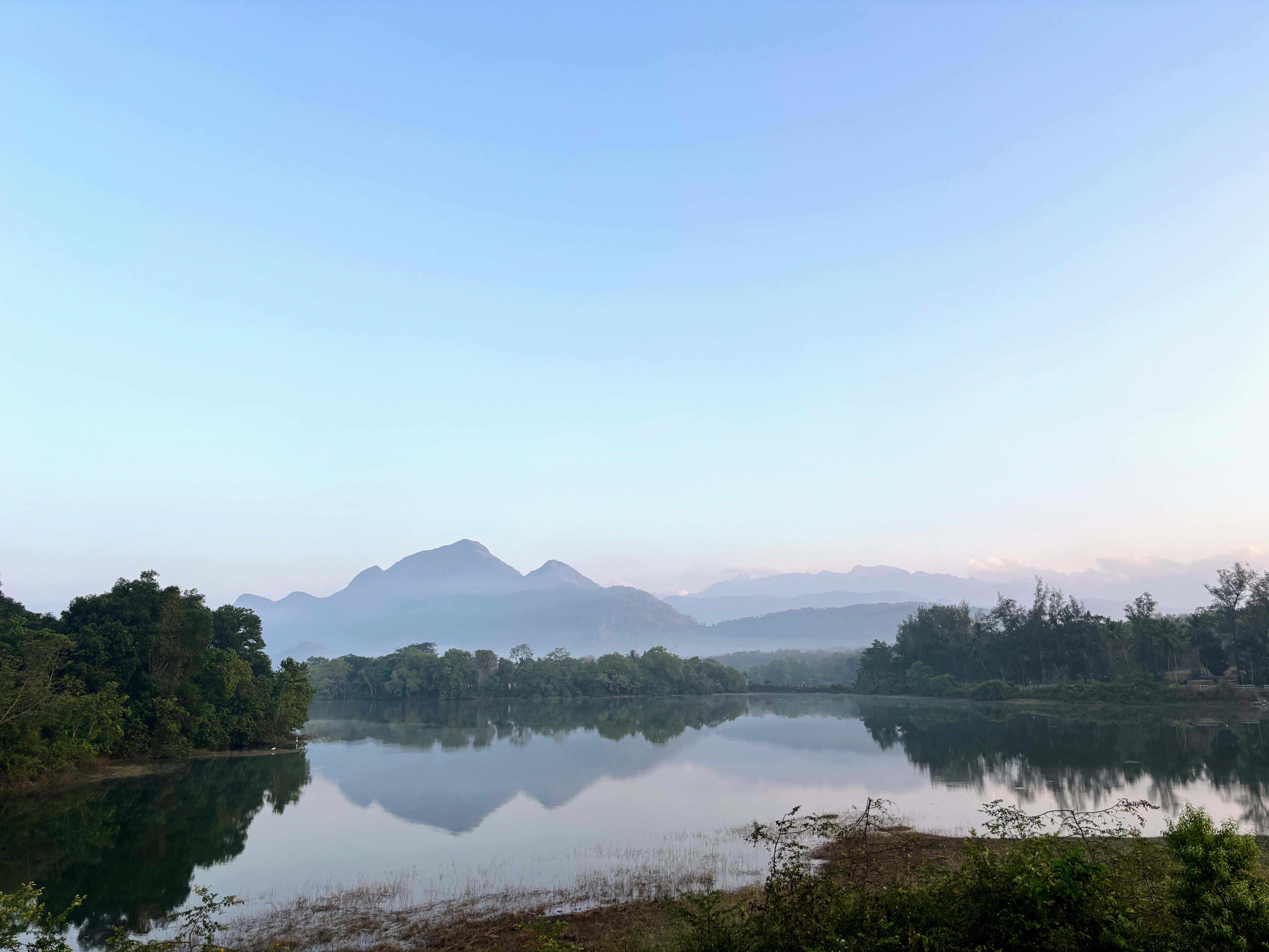 A lake nestled amidst rolling hills, with lush greenery adorning its shores