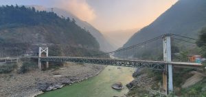 Large bridge in the mountains spanning over a river below.