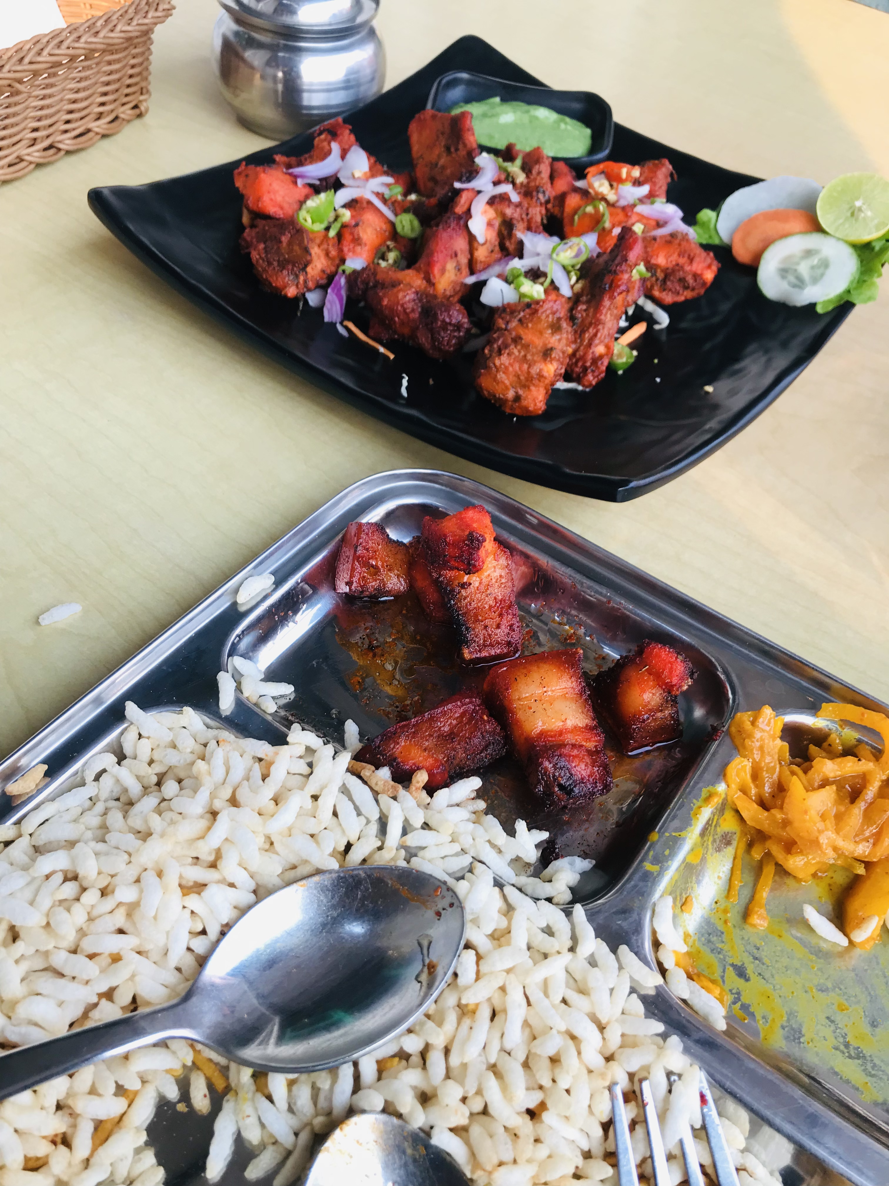 Tasty grilled pork sekuwa with a squeeze of lemon and a side of puffed rice.