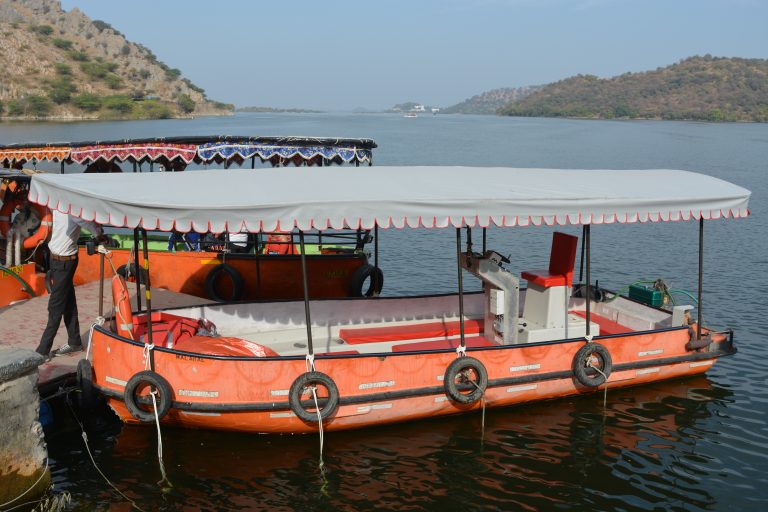 A boat on lake Jaisamand with hills surrounding the lake