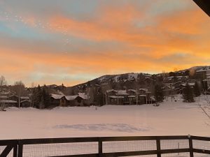 Early morning sunrise beginning over Steamboat Ski Resort in the background with snow covered Rollingstone Ranch Golf Course in the midground (Steamboat Springs, Colorado)