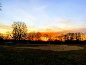 Sunset behind leaf-less trees, soccer goals, and a baseball field (Towson, Maryland)
