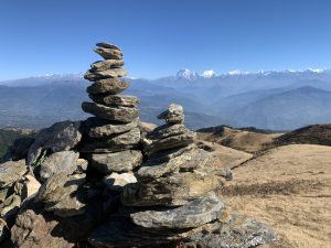 Stacked stones with snowy mountain ranges in the background.