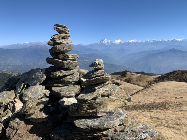 Stacked stones with snowy mountain ranges in the background.