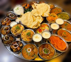 View larger photo: Indian cuisine including rice, chicken, naan, biryani, and other food items.