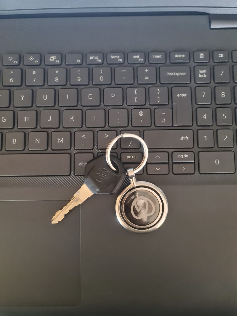 Bike’s key with the keyring is on the laptop keyboard.