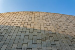 View larger photo: Concrete wall with a rectangular engraved pattern under a bright blue sky. 