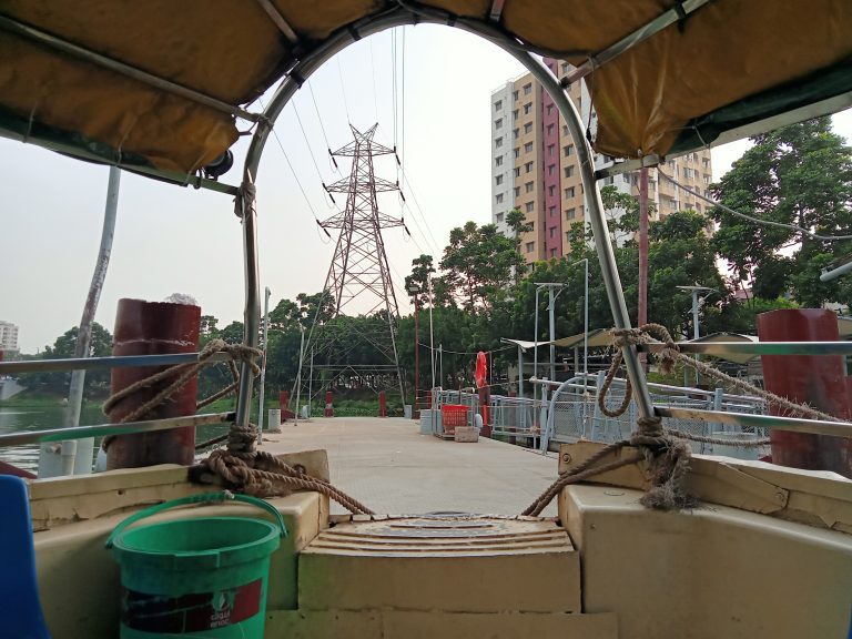 From inside the Hatir Jheel Water Taxi, Hatirjheel, Dhaka, Bangladesh, looking at the dock and electric power lines