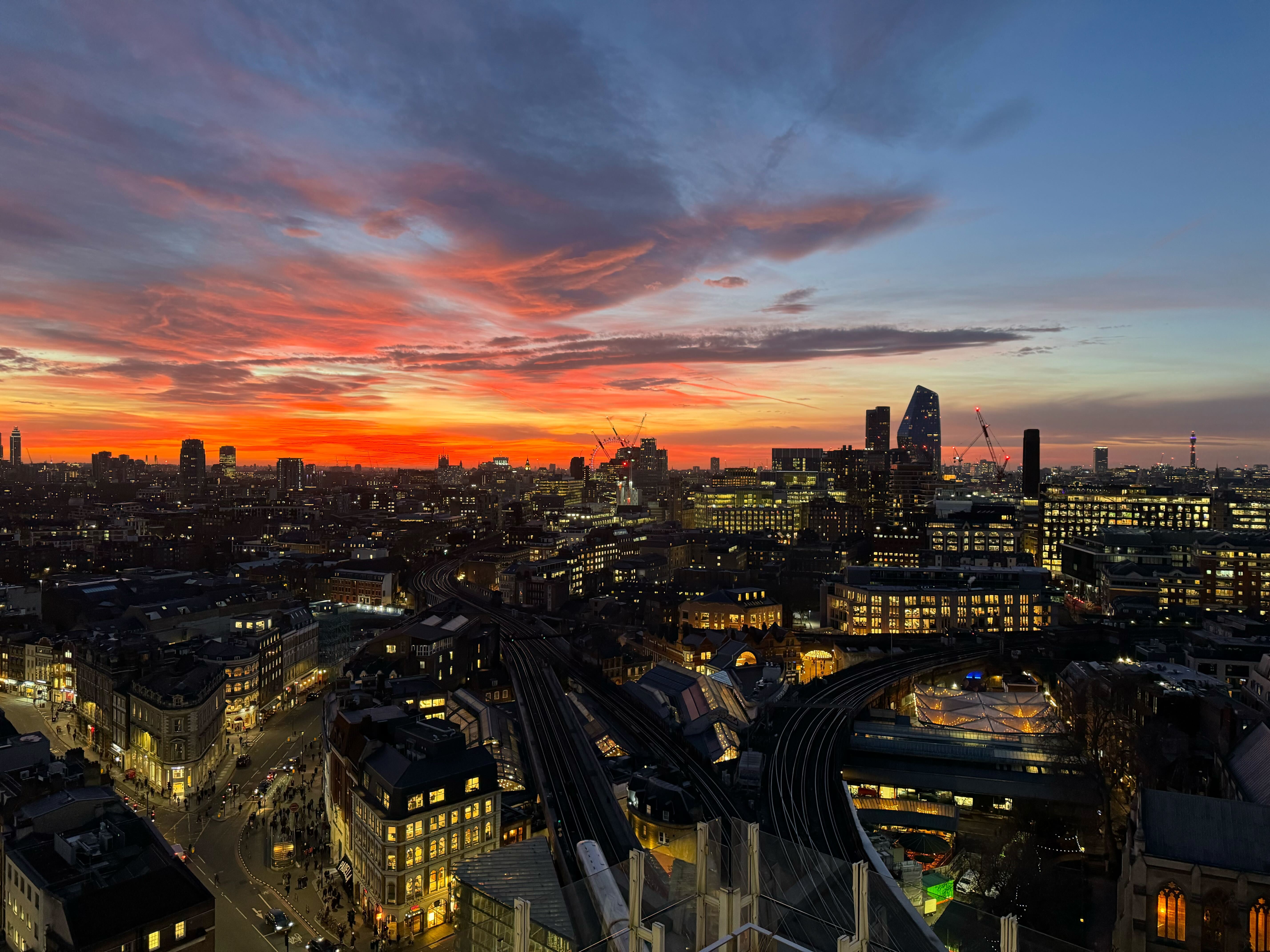 A view of the city of London at sunrise with the London Eye in the very back.