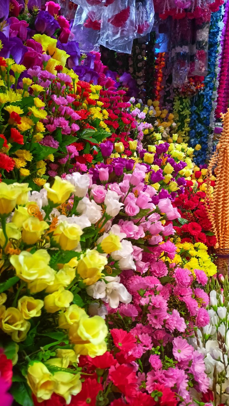 Artificial Flowers of multiple colours on a shop.