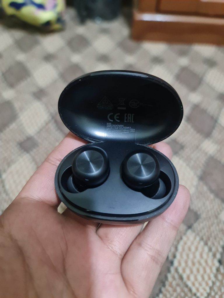 Black-colored earbuds held in hand.