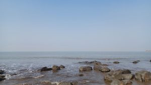 Large rocks on the shore of a vast body of water