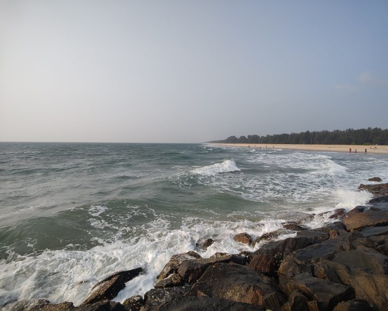 Beautiful beach view with rocks on the side.