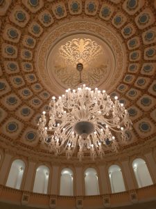 A large and ornate chandelier against an ornate ceiling.