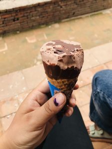 Brown chocolate ice cream held in hand.