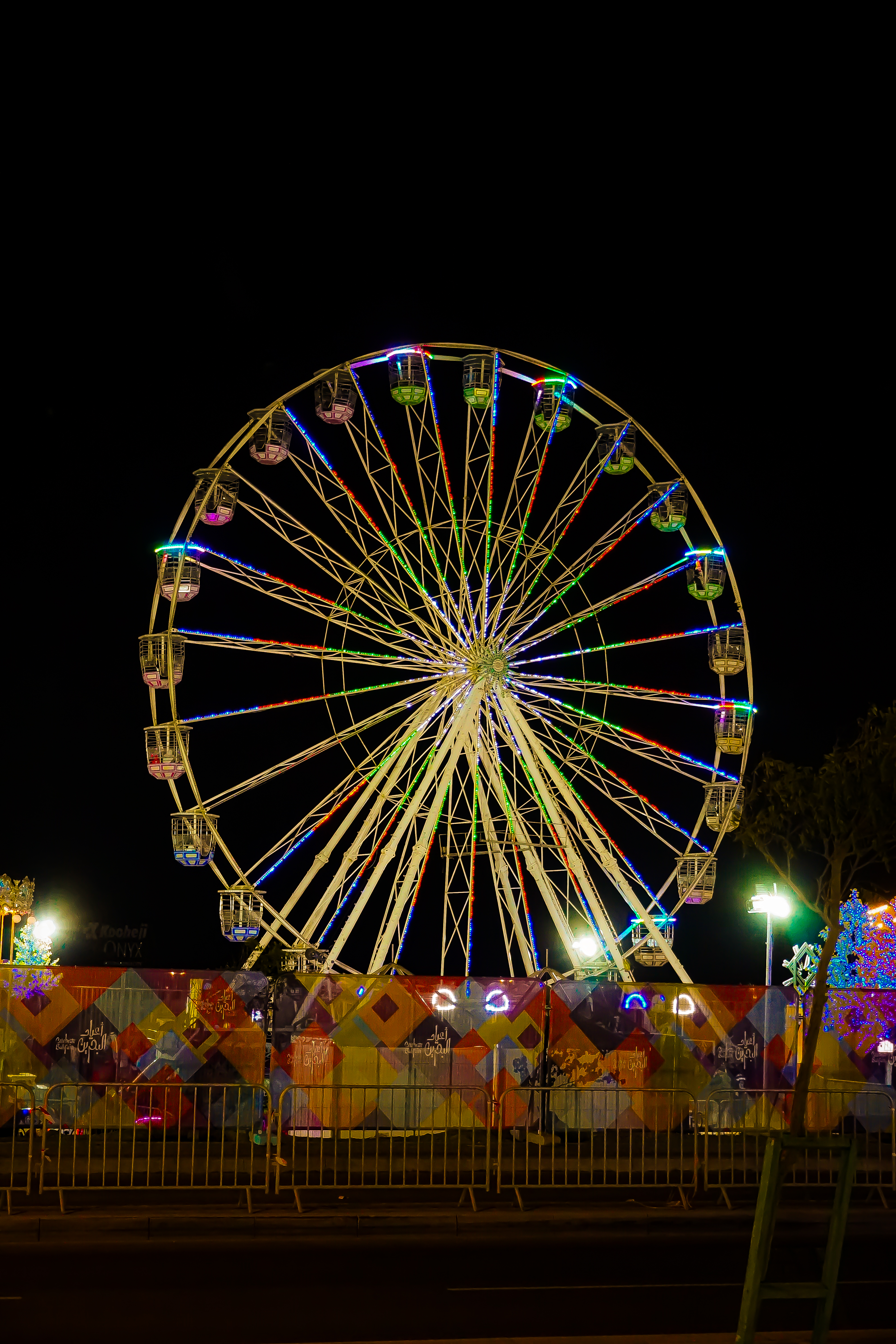 An illuminated ferris wheel at a vibrant city carnival festival featuring lively parades, and joyful crowds celebrating in the streets.