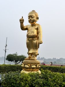 Standing tall in Lumbini, Nepal, this golden child statue points to the sky, symbolizing hope and the birthplace of Buddha.
