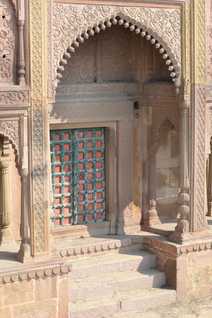 Pillars adorned with intricate designs and a massive door showcasing the beauty of traditional craftsmanship.
