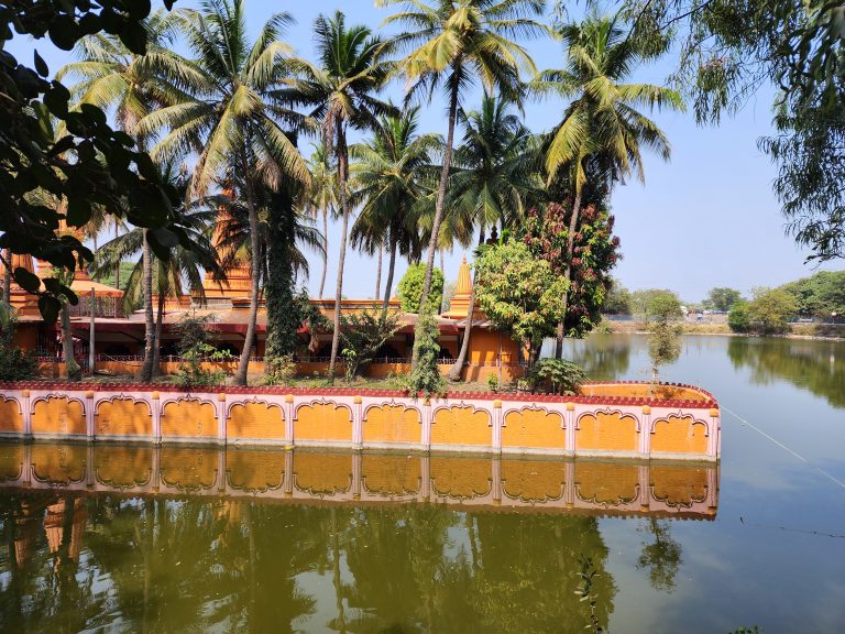 A temple behind coconut trees.