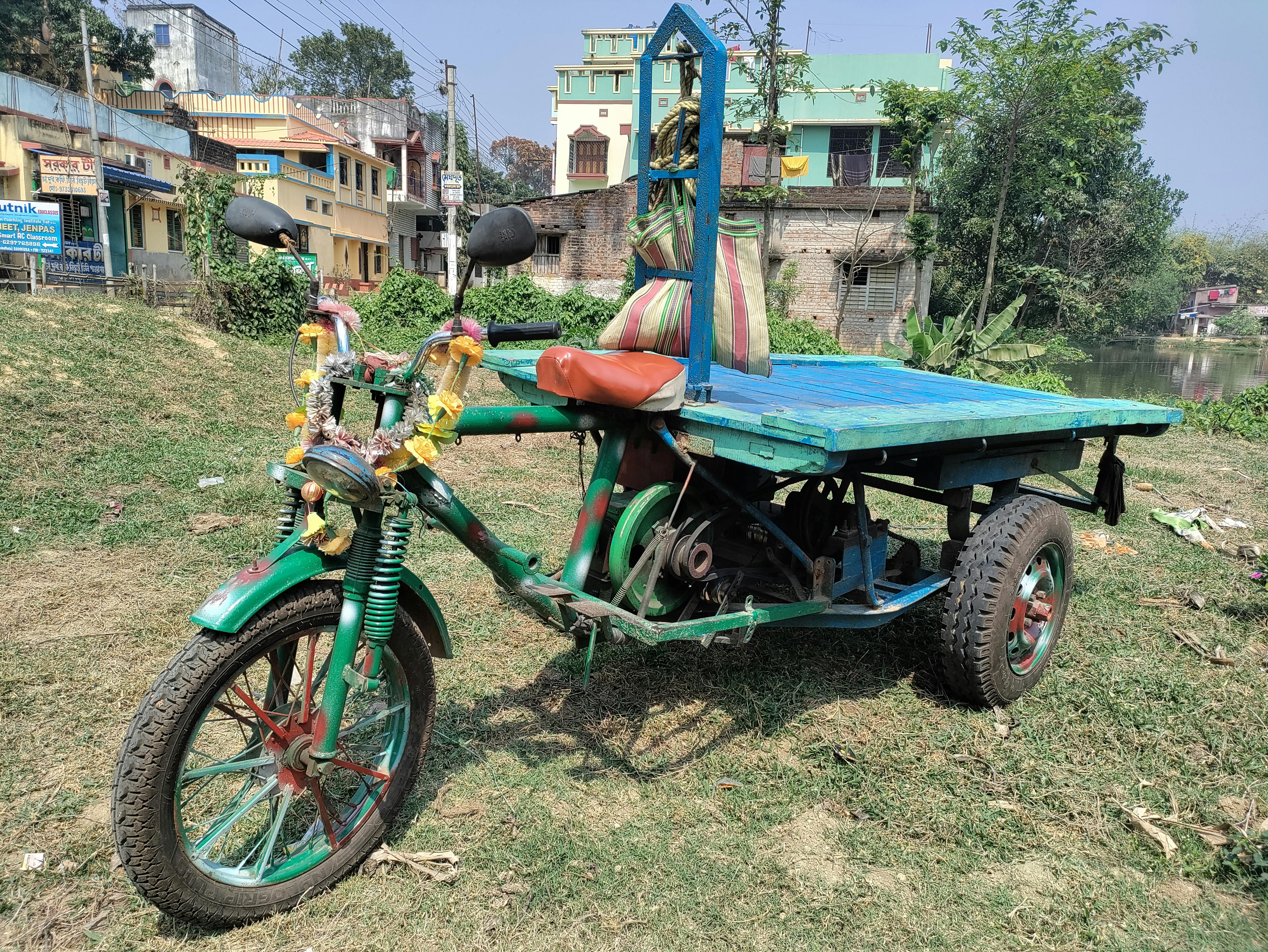 Three wheeled scooter with a flatbed on the back for carrying things.