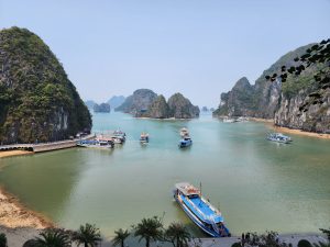 Boats on Ha Long Bay surrounded by rocky cliffs